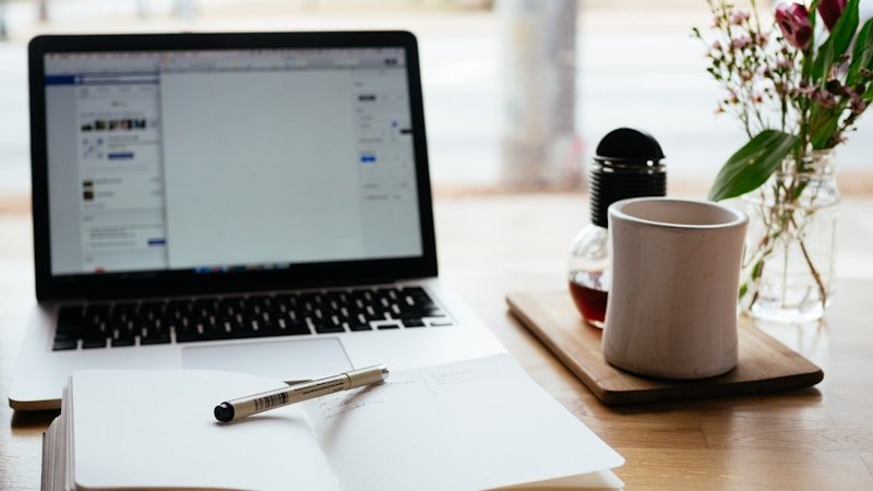 Person studying online course with notebook and laptop on a desk